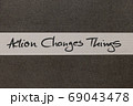 White and Grey coloured paper background with Action Changes Things motivational handwritten message 69043478