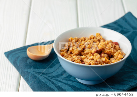 Bowl with granola on wooden table close up Bowl with granola on wooden table close up 69044458