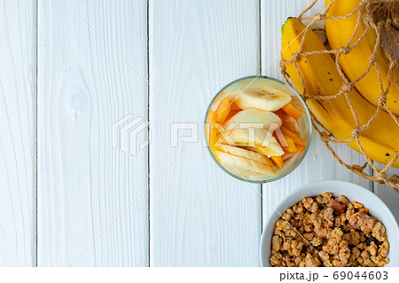 Tasty breakfast with granola, yoghurt and fruits in a glass bowl Tasty breakfast with granola, yoghurt and fruits in a glass bowl 69044603