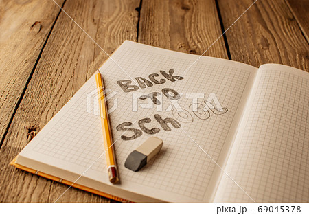 Back to school, the concept of raising children. Day of knowledge. Notebook in a slanting line on a wooden table with space for text. Save space. Rustic and vintage toning. Back to school, the concept of raising children. Day of knowledge. Notebook in a slanting line on a wooden table with space for text. Save space. Rustic and vintage toning. 69045378