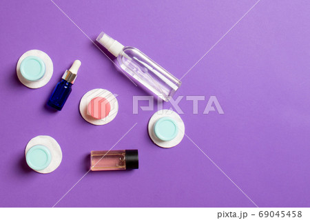 Set of travel size cosmetic bottles on colored background. Flat lay of cream jars. Top view of bodycare style concept 69045458