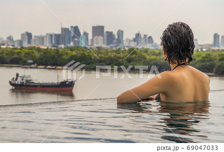 Side view of Short haired young woman relax in the roof top outd Side view of Short haired young woman relax in the roof top outd 69047033