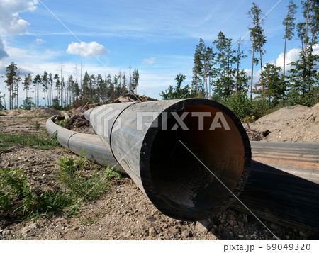 Environmental problems concept. Large pipes lay instead of felled wood. 69049320