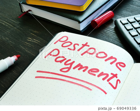 Postpone payments red memo on the page and calculator. Deferment or Forbearance concept. Postpone payments red memo on the page and calculator. Deferment or Forbearance concept. 69049336