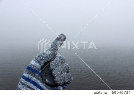 A man's hand in a woolen glove. In the palm of his 69049784