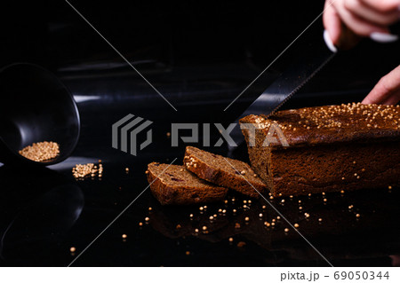 Homemade black bread on a black background. Photo in section. Homemade black bread on a black background. Photo in section. 69050344