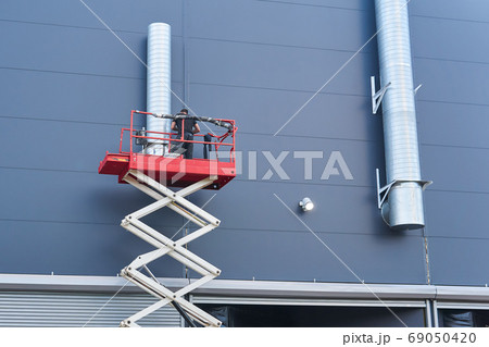 worker assembles the ventilation system of a building using a sc 69050420