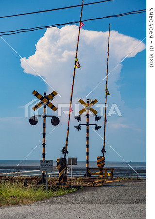 夏空に浮かぶ白い雲が見える海沿いの踏切 夏空に浮かぶ白い雲が見える海沿いの踏切 69050465