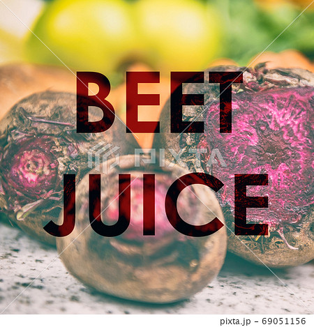BEET JUICE words written on photo background of fresh red beets in kitchen or farms market. Raw organic juicing trend of vegetable drink for weight loss. Title on sign for advertising 69051156