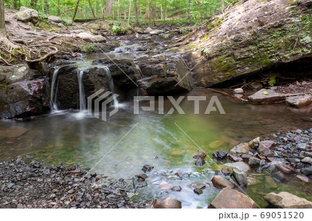 Long exposure of an ethereal forest waterfall Long exposure of an ethereal forest waterfall 69051520