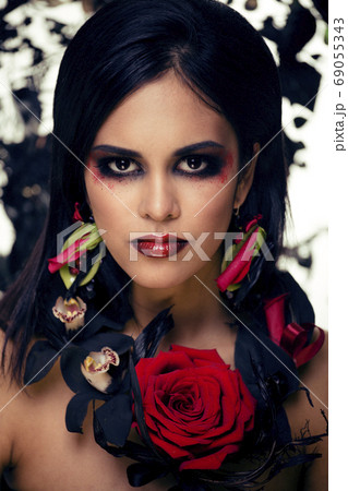 pretty brunette woman with rose jewelry, black and red, bright make up kike a vampire closeup red lips pretty brunette woman with rose jewelry, black and red, bright make up kike a vampire closeup red lips 69055343