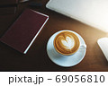 A latte coffee and laptop on the table.. 69056810