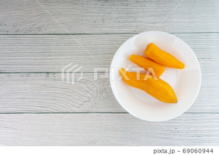 Ubi rebus or steam cassava is traditional malay dish on wooden background Ubi rebus or steam cassava is traditional malay dish on wooden background 69060944