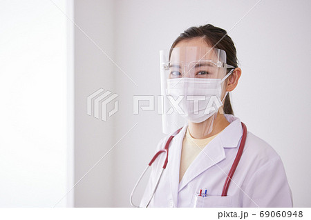 マスクとフェイスシールドをつけた若い女性医師 69060948