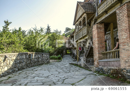 Narrow alley with old houses made of rough stone and brick columns,with wooden carved balconies in the Museum Tufenkian Old Dilijan Narrow alley with old houses made of rough stone and brick columns,with wooden carved balconies in the Museum Tufenkian Old Dilijan 69061555