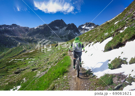 Mountain biking in a small narrow mountain path Mountain biking in a small narrow mountain path 69061621