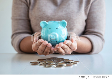 Young woman hands protection piggy bank and Young woman hands protection piggy bank and 69063657