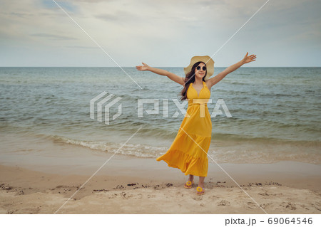 freedom woman with arms raised on sea beach with wind blow 69064546