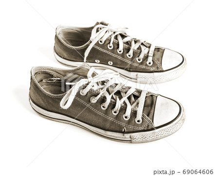 Old black sneakers isolated on white background 69064606