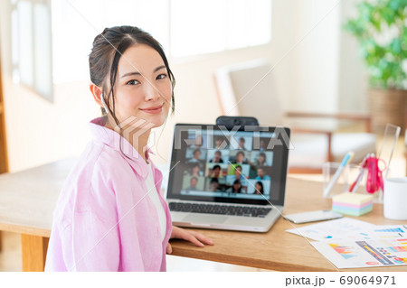 テレワーク  web会議中の画面と振り向く笑顔の若い女性 69064971