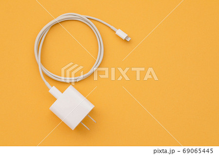 New white smartphone charger on orange background with copy spac 69065445
