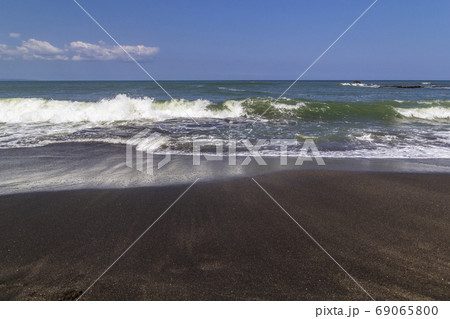 Black sand volcanic beach and white waves of ocean in Bali, Indonesia 69065800