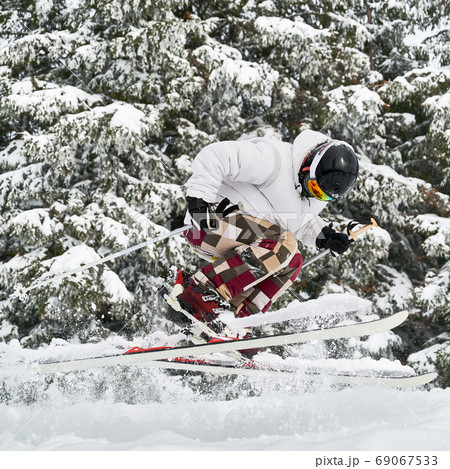 Young man on skis doing tricks with ski poles. Young man on skis doing tricks with ski poles. 69067533