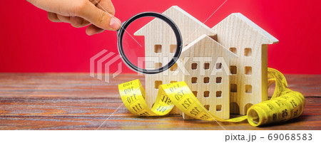 Miniature wooden houses and measuring tape. Home appraisal and property valuation concept. Housing construction, repair and maintenance. Real estate appraiser 69068583