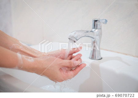 Woman washing hands, Corona virus travel prevention wash hands with soap and hot water. Hand hygiene for coronavirus outbreak. Protection by washing hands frequently concept. Woman washing hands, Corona virus travel prevention wash hands with soap and hot water. Hand hygiene for coronavirus outbreak. Protection by washing hands frequently concept. 69070722