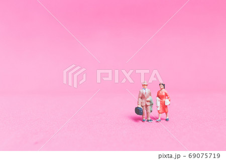 Miniature people Couple of travellers on pink background 69075719