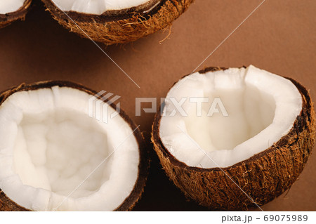 Coconut fruits on brown plain background Coconut fruits on brown plain background 69075989