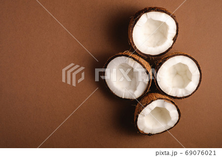 Coconut fruits on brown plain background Coconut fruits on brown plain background 69076021