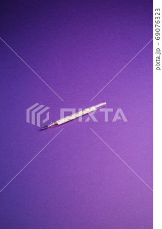 Analog thermometer on violet purple background 69076323