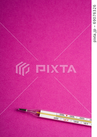 Analog thermometer on pink purple background Analog thermometer on pink purple background 69076326