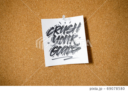 Crush your goal, motivational text written on reminder sticky note pinned on cork board Crush your goal, motivational text written on reminder sticky note pinned on cork board 69078580