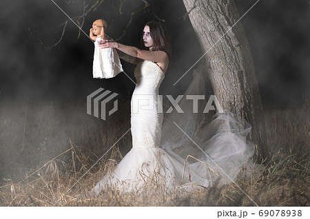 Horror Scene of a Woman Possessed holding a doll. 69078938