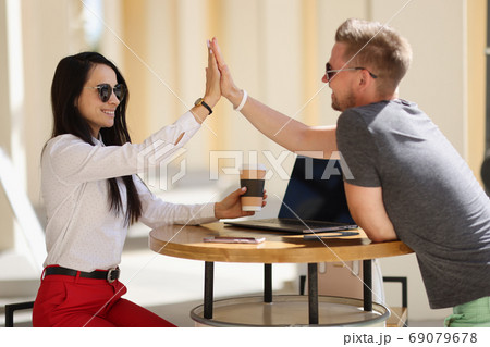 Smiling man and woman greet high five agreement. 69079678