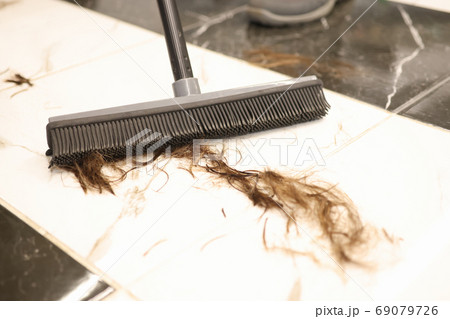 Floor brush is used to sweep cut hair in salon closeup 69079726