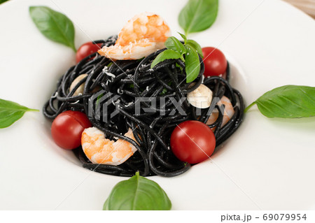 Black Spaghetti with Shrimps on White Restaurant Plate 69079954