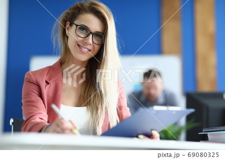 Student hold pen in one hand and folder in other hand in classroom and go through training. 69080325