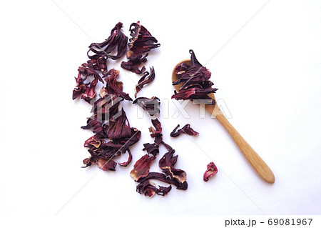 Red dried hibiscus flower leaves in a little wooden spoon, floral tea healthy drink, eco-friendly concept Red dried hibiscus flower leaves in a little wooden spoon, floral tea healthy drink, eco-friendly concept 69081967