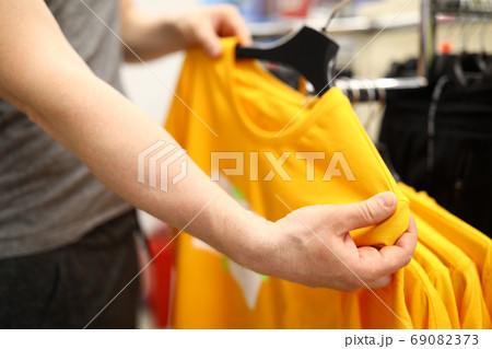 Young man holds a hanger with sportswear close-up 69082373