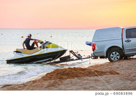 towing a jet ski to the shore 69083896