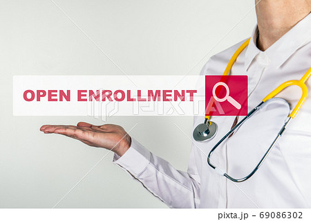 OPEN ENROLLMENT. Female doctor with stethoscope. Searching for information on the Internet OPEN ENROLLMENT. Female doctor with stethoscope. Searching for information on the Internet 69086302