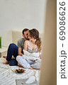 The husband hugs and kisses his beloved wife at home. 69086626