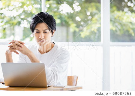 ノートパソコンの画面に見入っている若い男性 ノートパソコンの画面に見入っている若い男性 69087563