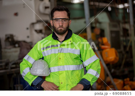 Portrait of male Engineer standing with confident against machine environment in factory Portrait of male Engineer standing with confident against machine environment in factory 69088655