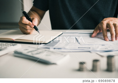 Man use calculators and documents that calculate expenses in the Man use calculators and documents that calculate expenses in the 69089878