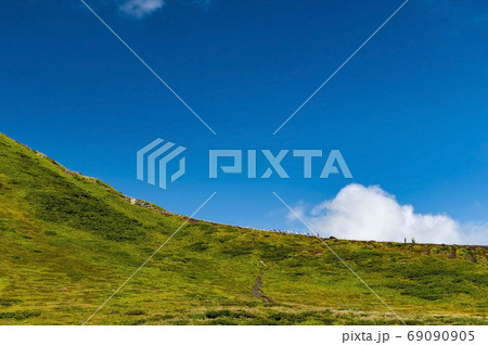秋田駒ヶ岳の男女岳を登る登山者と青空と白い雲 秋田駒ヶ岳の男女岳を登る登山者と青空と白い雲 69090905