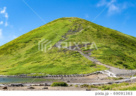 秋田駒ヶ岳の男女岳の登山道と阿弥陀池と木道と青空 69091363